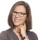 Eine lächelnde Frau mit Brille und mittellangem Haar blickt freundlich in die Kamera.