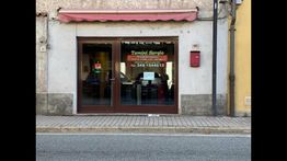 Vetrina di un negozio "Tavoli Sergio", con tenda rossa e marciapiede davanti.