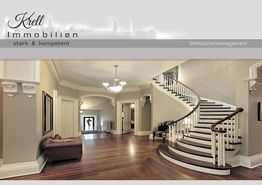 Eleganter Eingangsbereich mit geschwungener Treppe, Holzboden und klassischer Einrichtung.