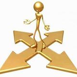 Boneco dourado em encruzilhada de setas, simbolizando escolha de caminhos diferentes.