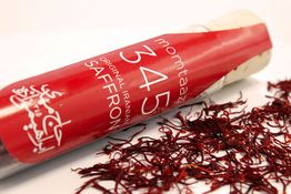 Rote Safranfäden und eine rote Verpackung mit der Aufschrift "Original Iranian Saffron".