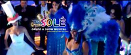 Grupo musical en fiesta, con disfraces y gorros coloridos, y texto "Sole Grupo & Show Musical".