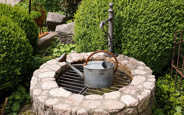 Gartenbrunnen mit einer Gießkanne