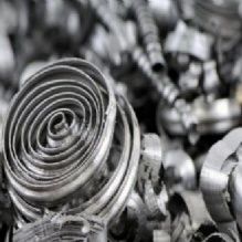 Close-up of coiled metal shavings in a pile, showcasing their spiral shapes and metallic texture.