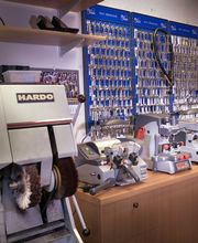 Schlüsselmaschinen und zahlreiche Schlüssel an einer Werkstattwand aufgereiht.