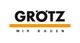 Logo von "GRÖTZ" mit gelbem Streifen darunter, der Text "Wir bauen" darunter in Schwarz.