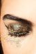 Glitzerndes Augen-Make-up mit geschlossenem Lid, funkelnde Partikel auf Wange und um Auge.