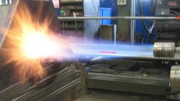 Getto di plasma in un'officina metalmeccanica. Energia luminosa e scintille visibili.