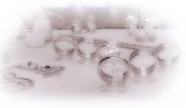 Mehrere funkelnde Silberringe und Schmuckstücke auf einem hellen Hintergrund präsentiert.