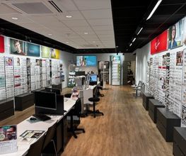 Een brillenwinkel met vitrines vol brillen en enkele bureaus voor klantenservice.