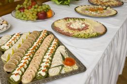 Vorspeisenbuffet mit belegten Broten und Platten aus Käse und Aufschnitt, verziert mit Obst.