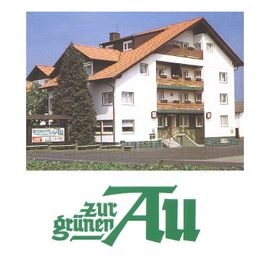 Weiße Pension mit roten Dächern, großer Tanne, Schild "Zur Grünen Au".