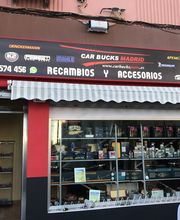 Tienda de recambios y accesorios para autos en Madrid, con letrero rojo y toldo a rayas.