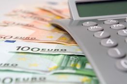Taschenrechner auf Euroscheinen, darunter ein 100-Euro-Schein.