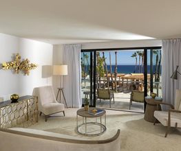 Sala moderna con muebles elegantes y vista al mar desde la terraza.