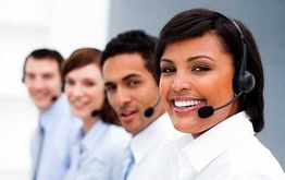 Smiling customer service team wearing headsets, standing in a row.