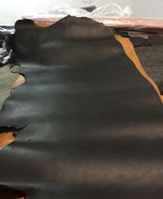 Piel de cuero negra extendida sobre una mesa.