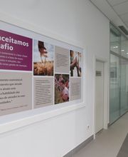 Corredor com quadro na parede sobre desenvolvimento sustentável e inovação em empresa.