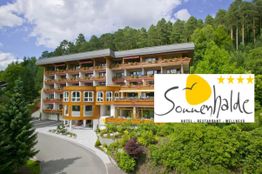 Hotel im Grünen mit Sonnenhalde-Logo, vier Sterne.
