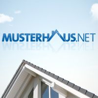 Schrägdach eines Hauses mit blauem "MUSTERHAUS.NET"-Schriftzug auf blauem Himmel.