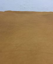 Superficie de cuero marrón claro con textura suave y fondo blanco difuminado.