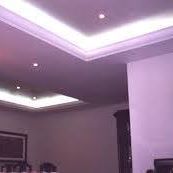 Teto com iluminação embutida em um ambiente fechado e paredes claras.