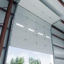 Large open garage door with windows, revealing trees outside.