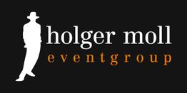 Logo: Silhouette eines Mannes mit Hut, Text "holger moll eventgroup" auf schwarzem Hintergrund.