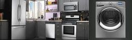 Modern kitchen with stainless steel appliances, including a fridge, oven, and washer.