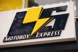 Placa com logotipo amarelo de raio e o texto "Motoboy Express" em preto.