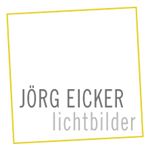Quadratisches Logo mit gelbem Rand, Text: "Jörg Eicker Lichtbilder" in Grau.