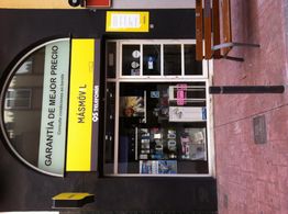 Tienda de telefonía móvil con letreros amarillos y vitrinas con productos expuestos.