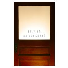 Wooden door with frosted glass labeled "Private Investigation" in reverse lettering.