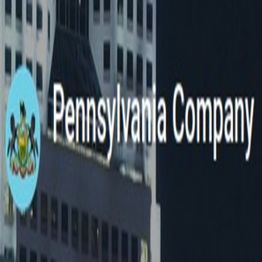 Sign reading "Pennsylvania Company" with a seal, on a building in the background.