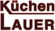 Logo mit der Aufschrift "Küchen Lauer" in stilisierter, rot-schwarzer Schrift.