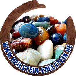 Bunte Edelsteine in einem hölzernen Hufeisenrahmen mit der Website www.heilstein-edelstein.de.