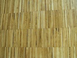 Holzparkettboden mit langen, schmalen Planken in verschiedenen hellbraunen Tönen.