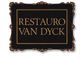 Cartel negro con borde decorativo dice "Restauro Van Dyck" en letras doradas.