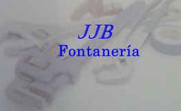 Texto "JJB Fontanería" sobre herramientas de plomería desenfocadas en el fondo.