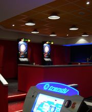 Spielhalle mit Dartautomaten und leuchtenden Spielekonsolen in einem modern beleuchteten Raum.