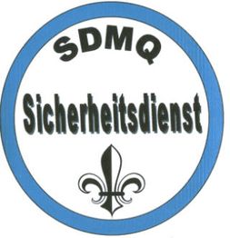 Abzeichen mit blauem Rand, Schriftzug "SDMQ Sicherheitsdienst" und einem Fleur-de-Lis-Symbol.
