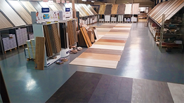 Winkelinterieur met vloermonsters in diverse houttinten. Planken staan en liggen uitgestald.