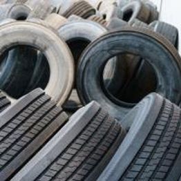 Stack of old, worn tires piled haphazardly, showing various treads and grooves.