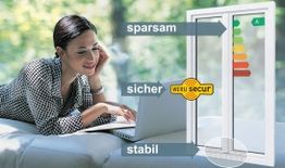 Frau liegt mit Laptop, betrachtet Fenster mit Energieetikett. Text: sparsam, sicher, stabil.