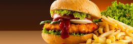 Hamburger con lattuga e ketchup, contornato da patatine fritte. Sfondo scuro sfumato.