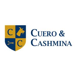Wappen mit Schere, Ziege und Initialen des Logos "Cuero & Cashmina" auf gelb-blauem Hintergrund.