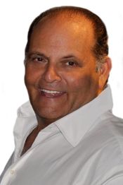 A man in a white shirt smiling at the camera.