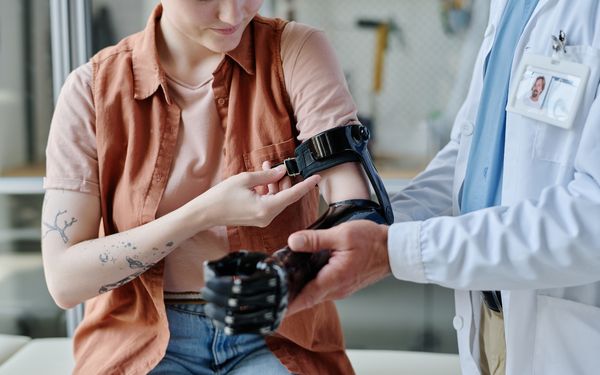 Ein Arzt legt einer Patientin eine Armprothese an.