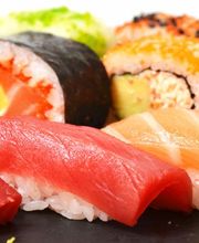 Variedad de sushi: nigiri y rollos con pescado, aguacate y arroz, en un plato.