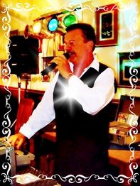 Ein Mann singt in einem Raum mit Mikrofon, umgeben von leuchtenden Lichtern und Dekorationen.